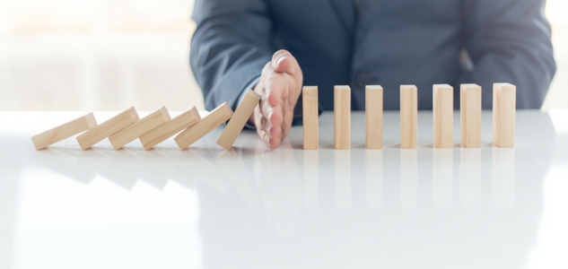 Hand Stopping Dominoes From Falling Connoting Risk Management